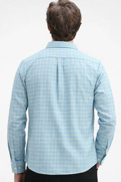 Person wearing a light blue checkered shirt on a white background