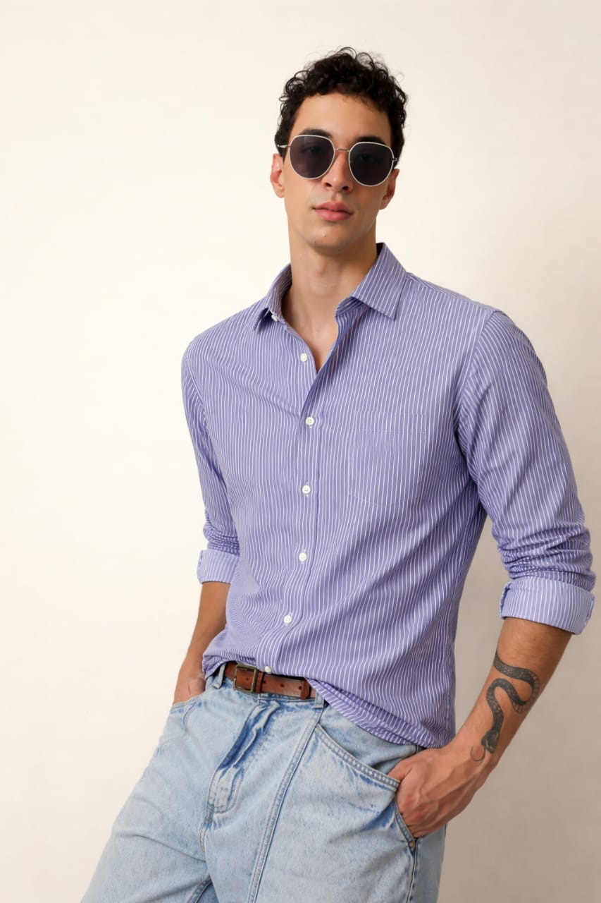 Man wearing a purple striped shirt and sunglasses against a plain background
