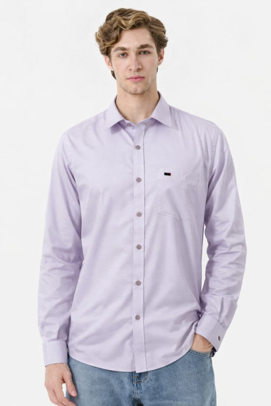 Man wearing a light purple button-up shirt with a small black logo on a white background