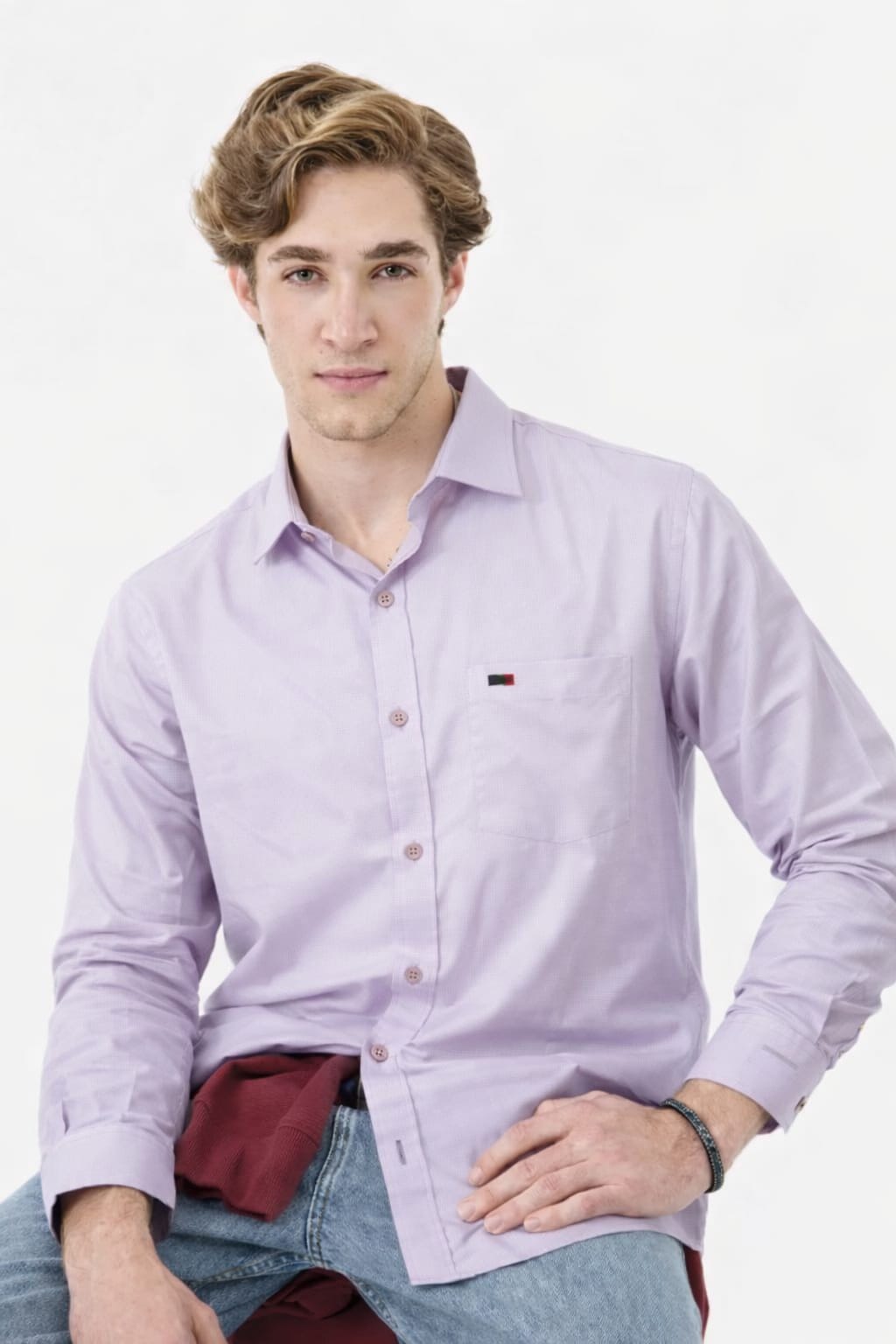 Man wearing a light purple button-up shirt with a small logo on a white background