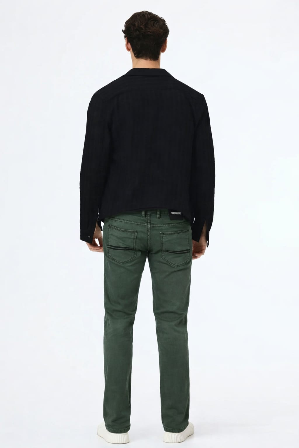 Person wearing a black shirt and green pants on a white background