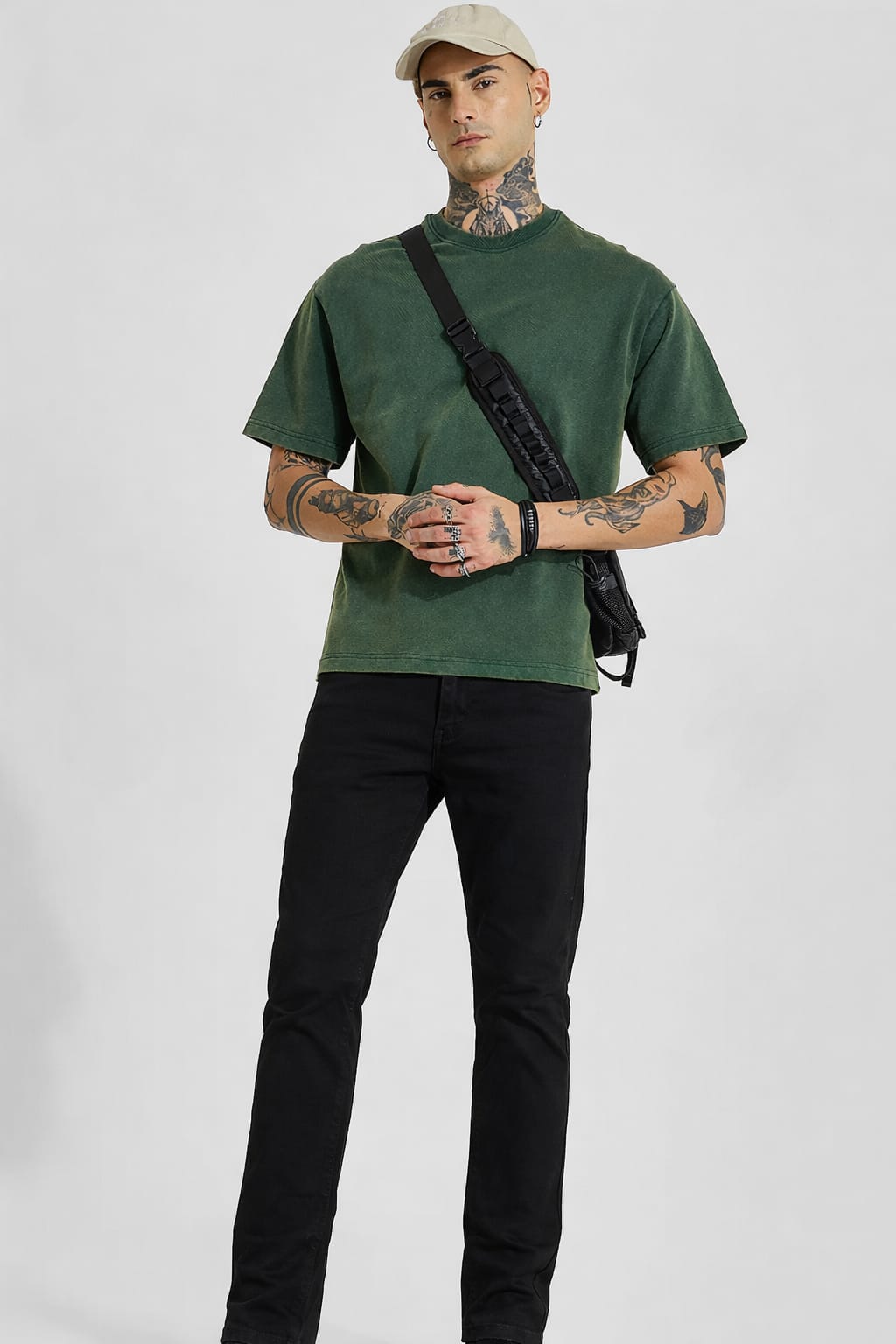 Man wearing a green t-shirt and black pants with a white background
