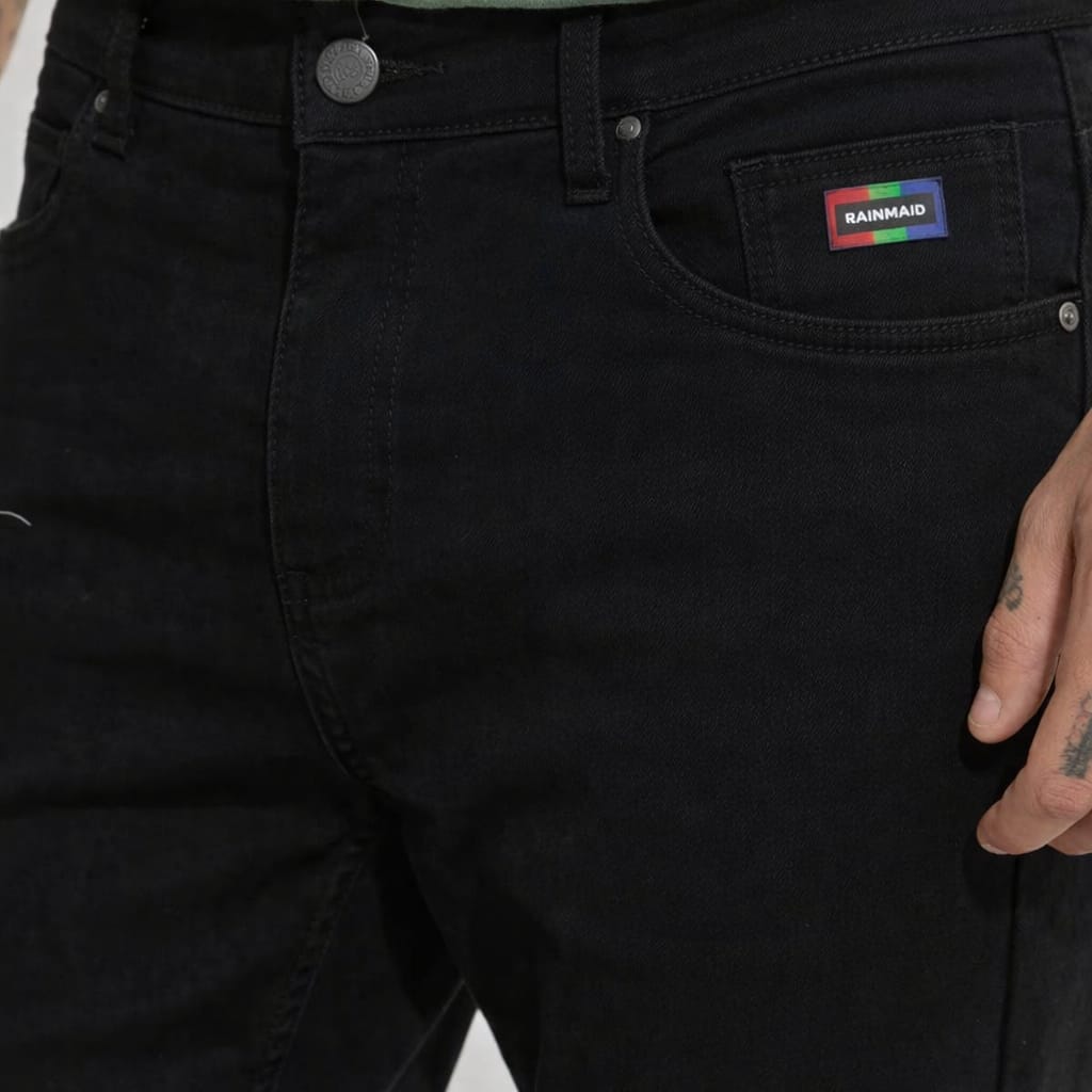 Black pants with a brand logo on the pocket against a neutral background