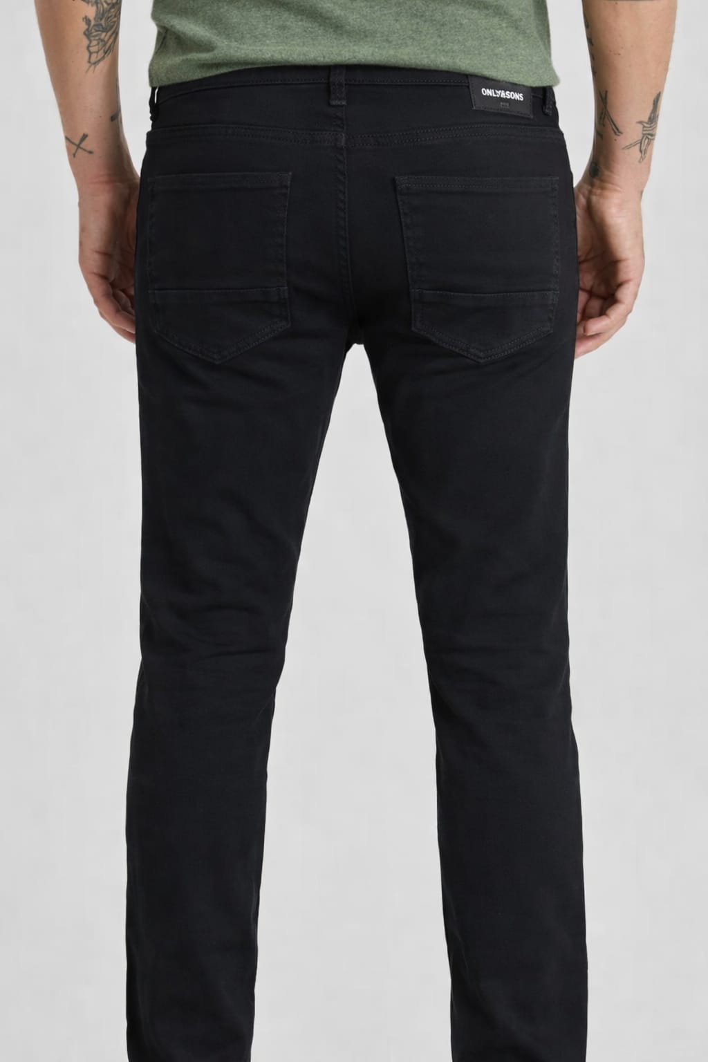 Person wearing black pants with a visible brand logo on a white background