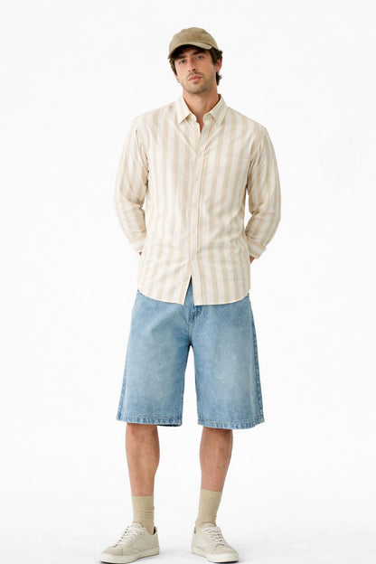 Man wearing a striped shirt, cap, and shorts on a white background