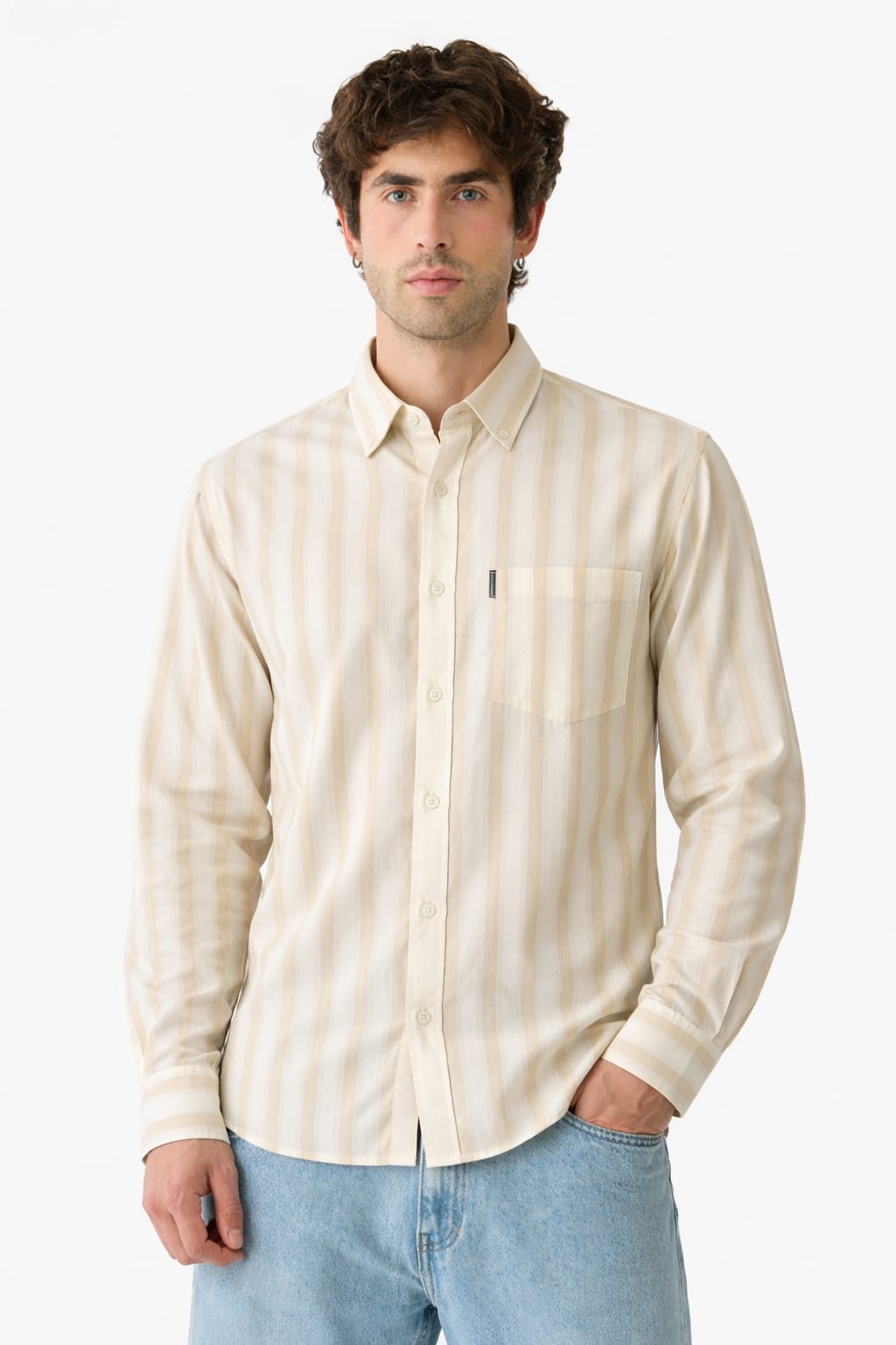 Man wearing a beige striped shirt and light blue jeans on a white background