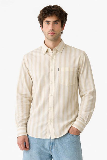 Man wearing a beige striped shirt and light blue jeans on a white background