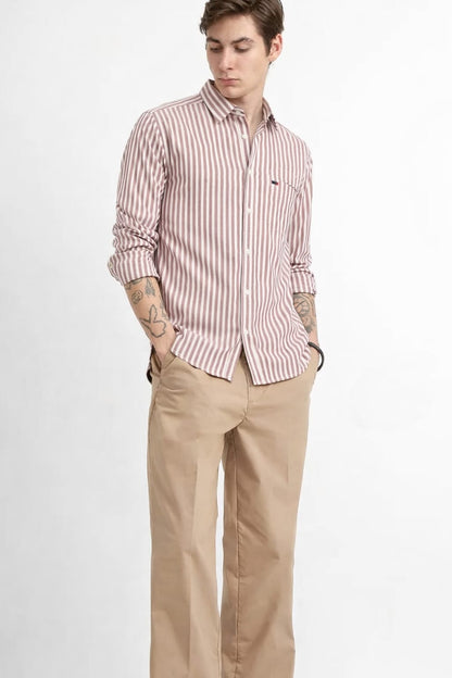 Man wearing a striped shirt and beige pants on a white background