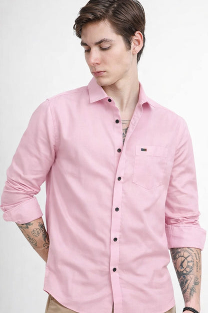 Man wearing a pink shirt with a brand logo on a white background