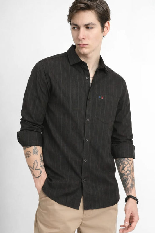 Man wearing a black pinstripe shirt with a visible brand logo on a white background