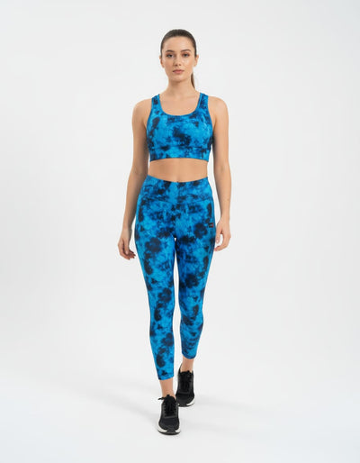 Woman wearing a blue tie-dye athletic outfit on a white background
