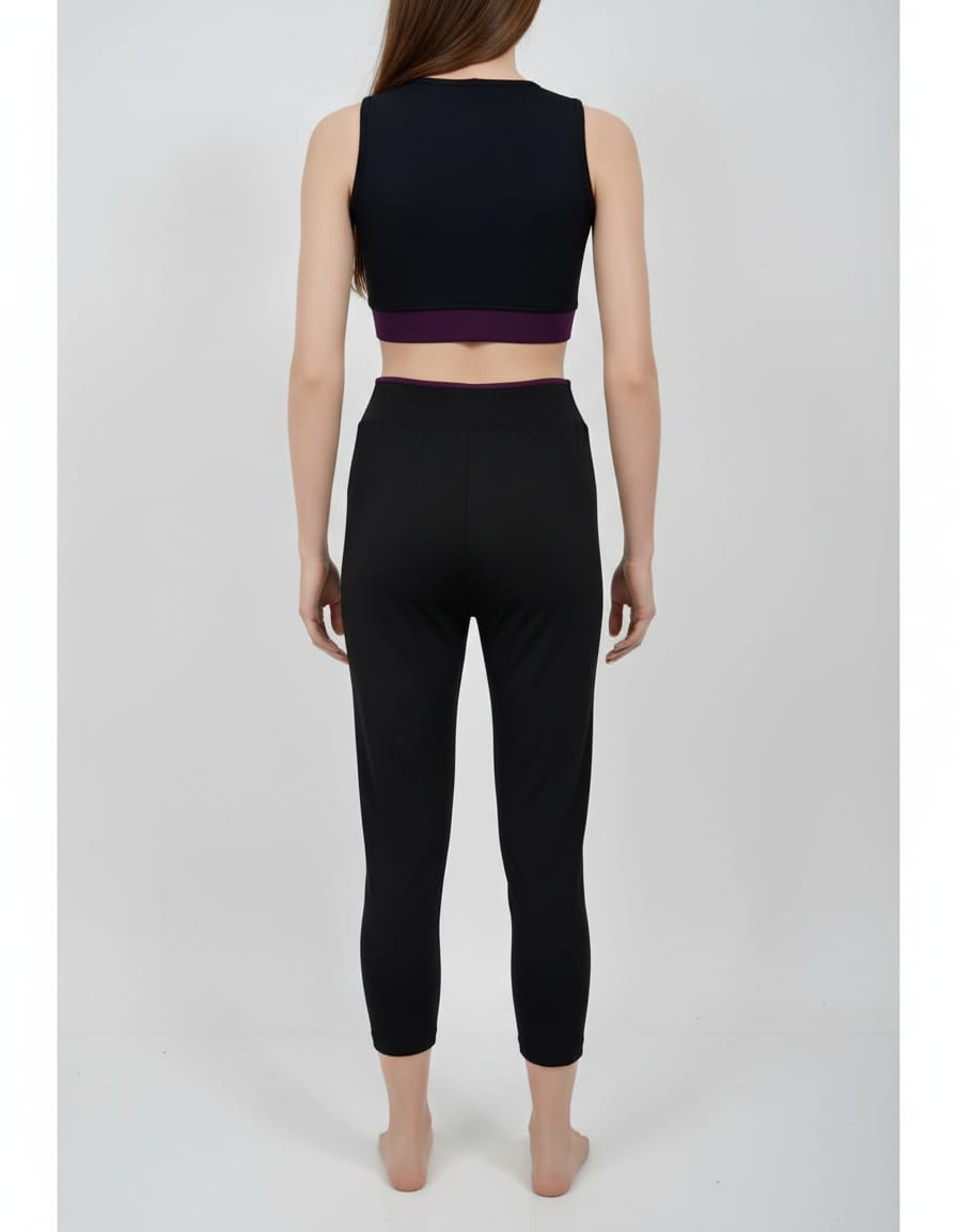 Person wearing a black sports bra and leggings set on a white background