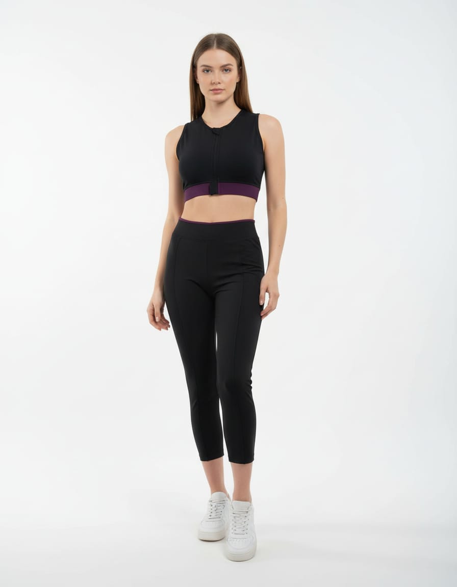 Woman wearing a black athletic outfit with a purple accent on a white background