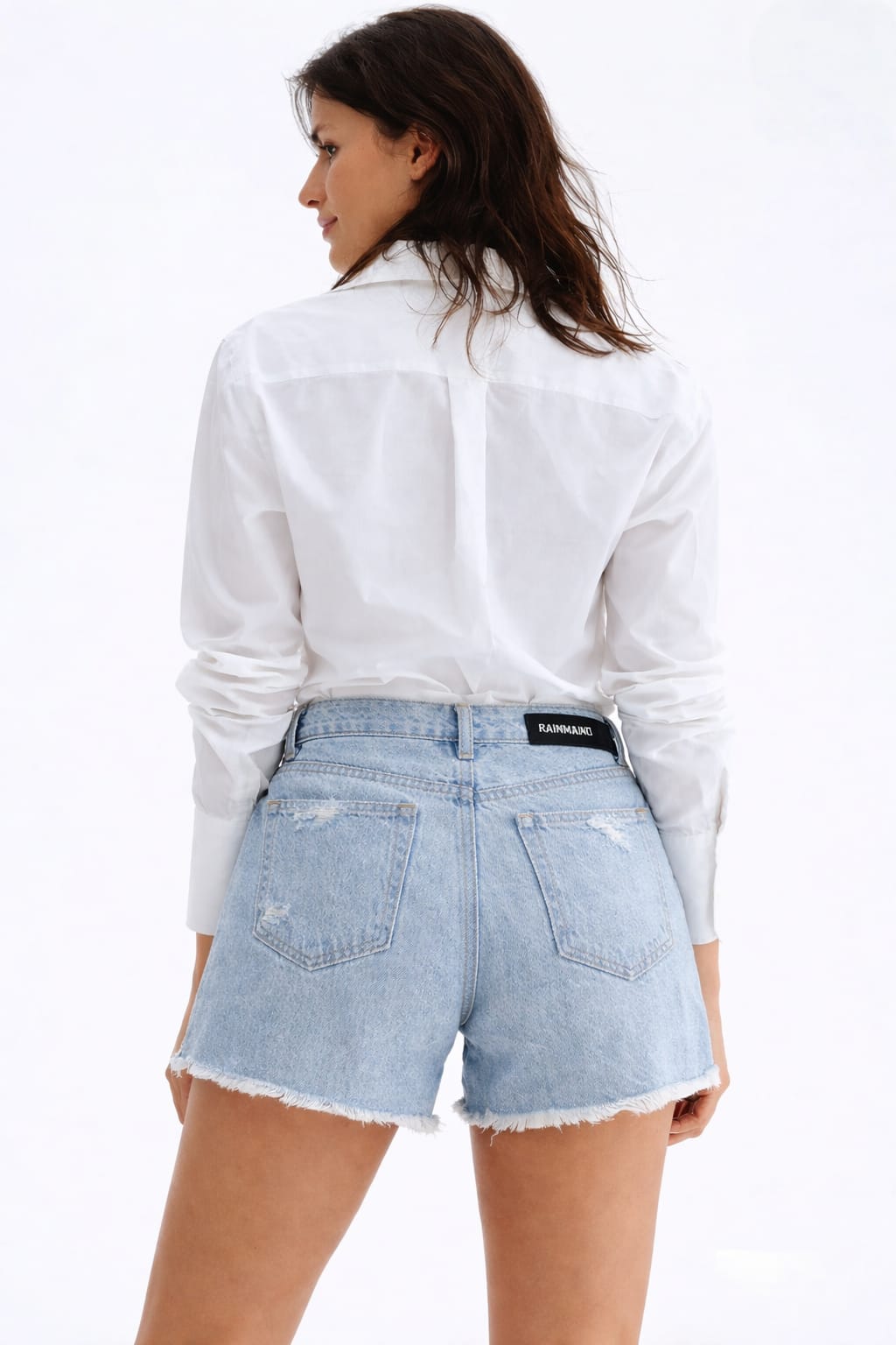 Woman wearing a white shirt and denim shorts on a white background