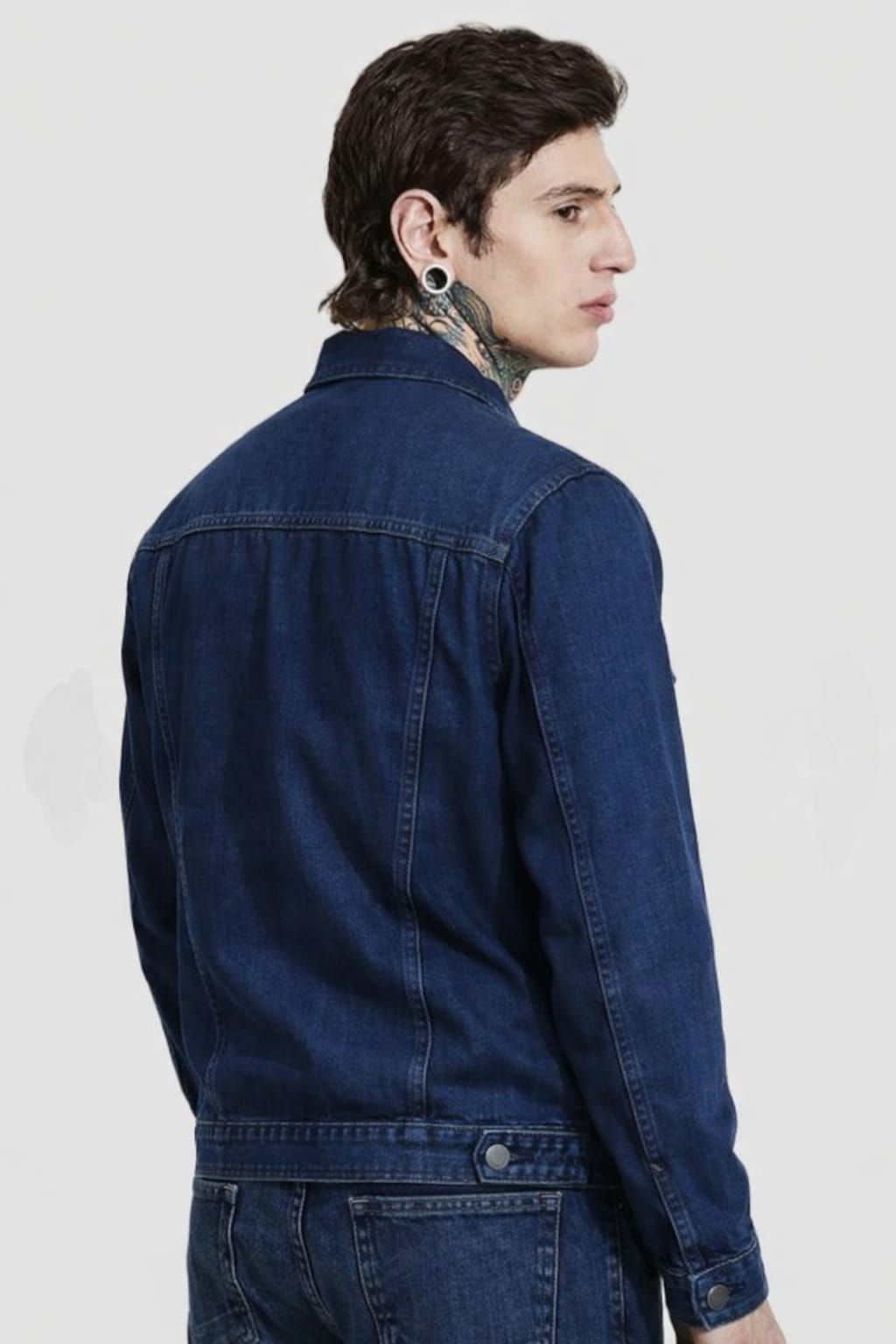 Person wearing a blue denim jacket on a white background