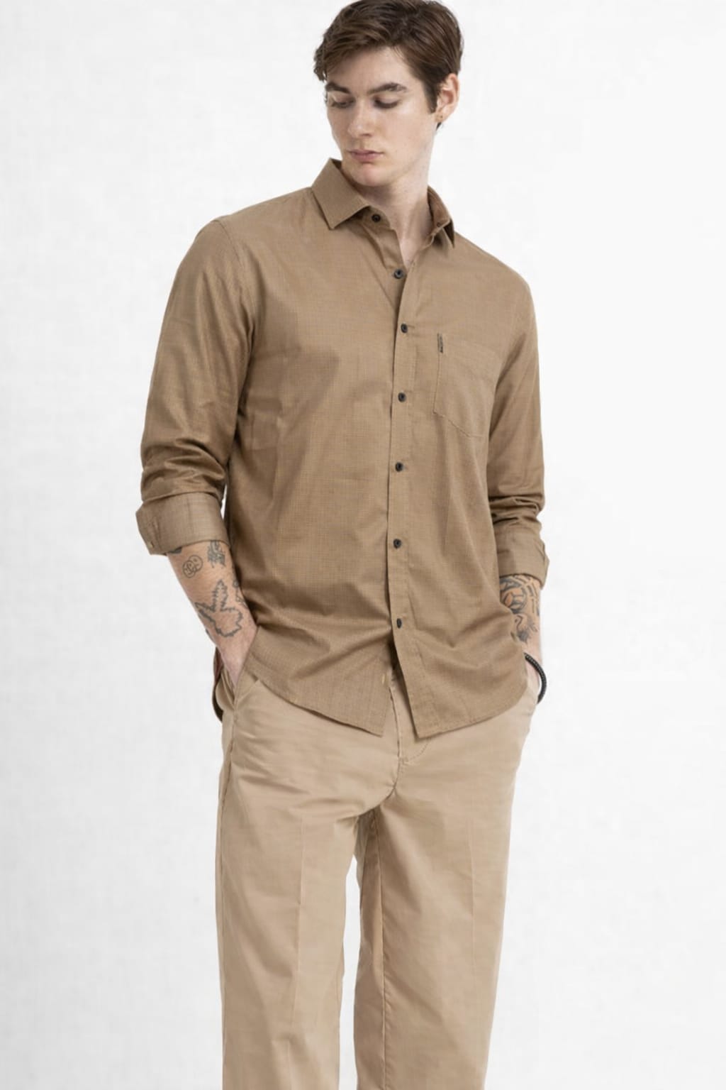 Man wearing a beige shirt and pants on a white background