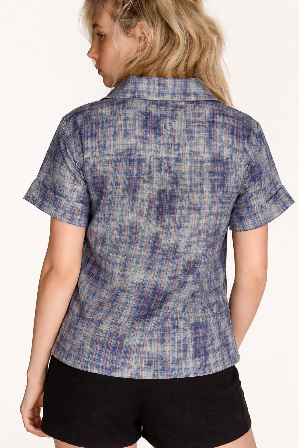 Person wearing a blue plaid shirt on a white background