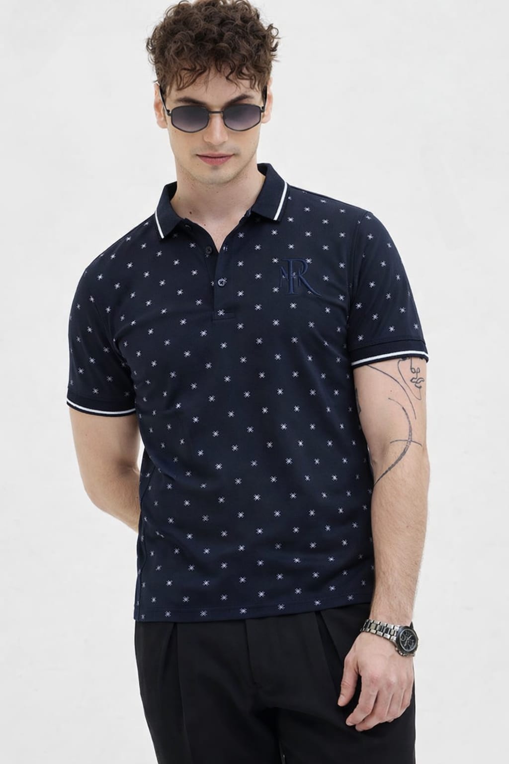 Man wearing a navy blue polo shirt with white pattern on a white background