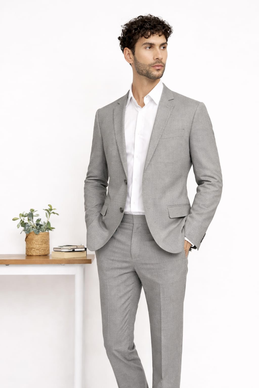 Man wearing a gray suit with a white shirt in an indoor setting