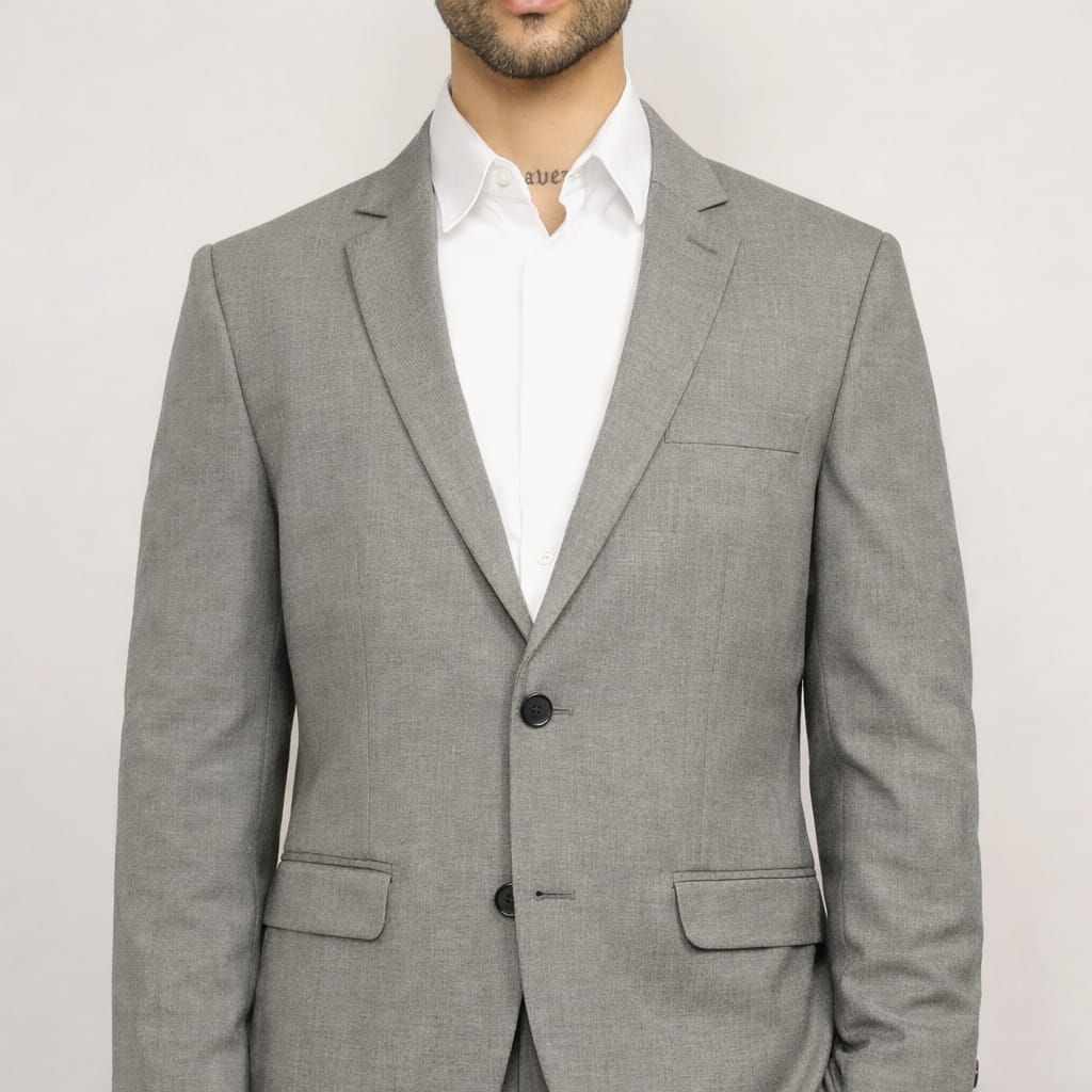 Gray suit jacket worn by a person on a plain background