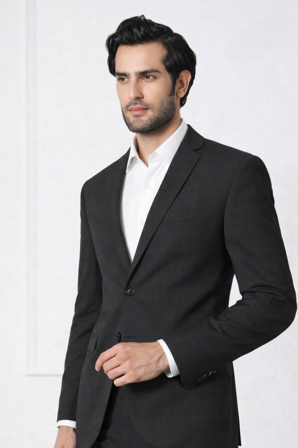 Man wearing a black suit jacket over a white shirt on a white background