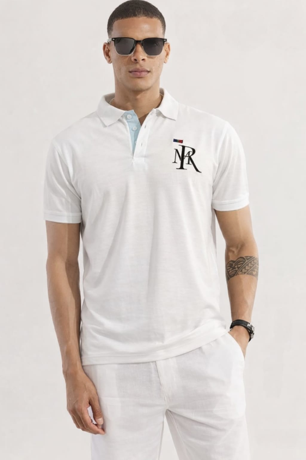 Man wearing a white polo shirt with a logo on a light gray background