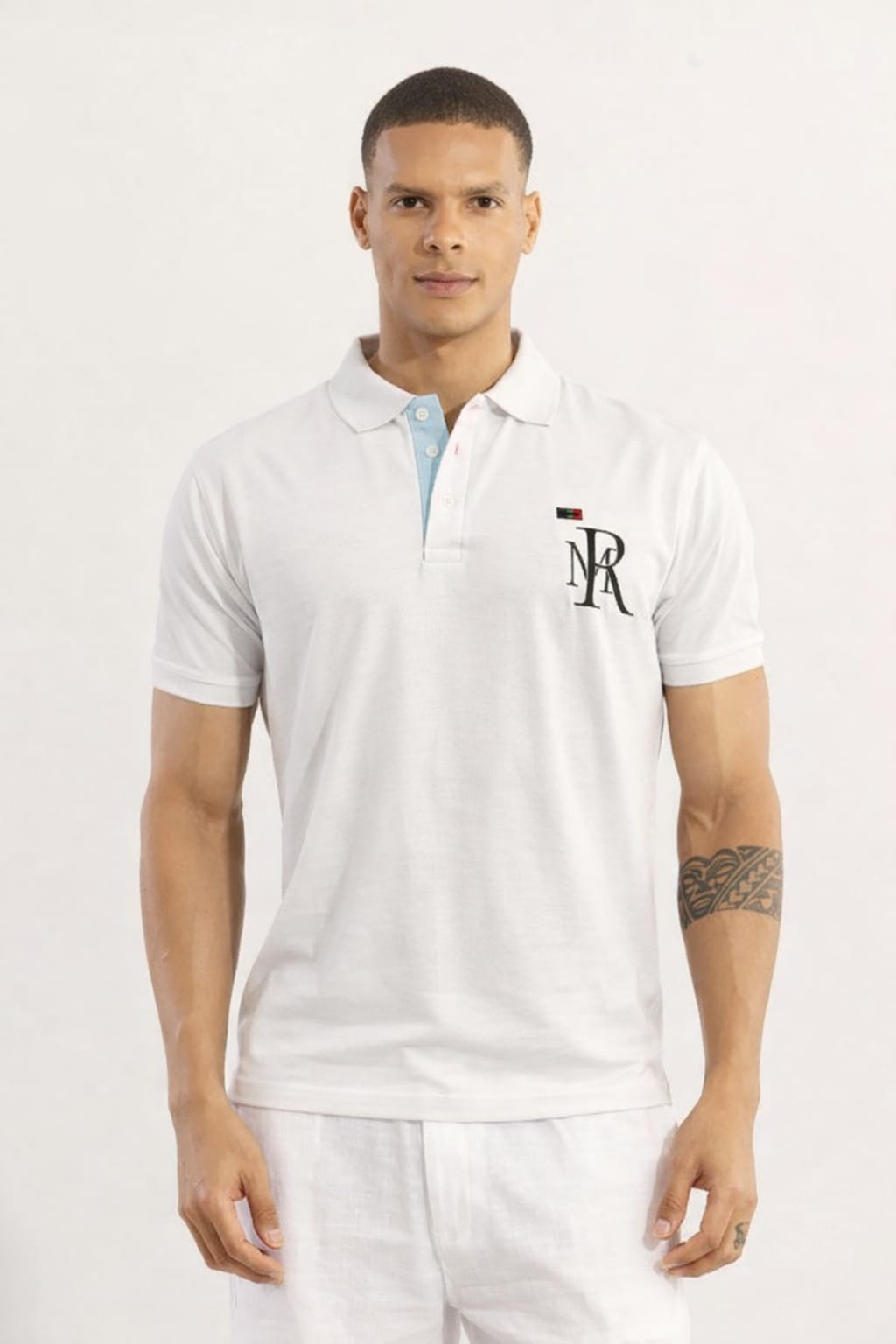 Man wearing a white polo shirt with a logo on a light gray background