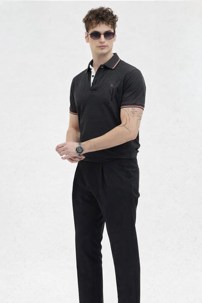 Man wearing a black polo shirt and pants on a white background