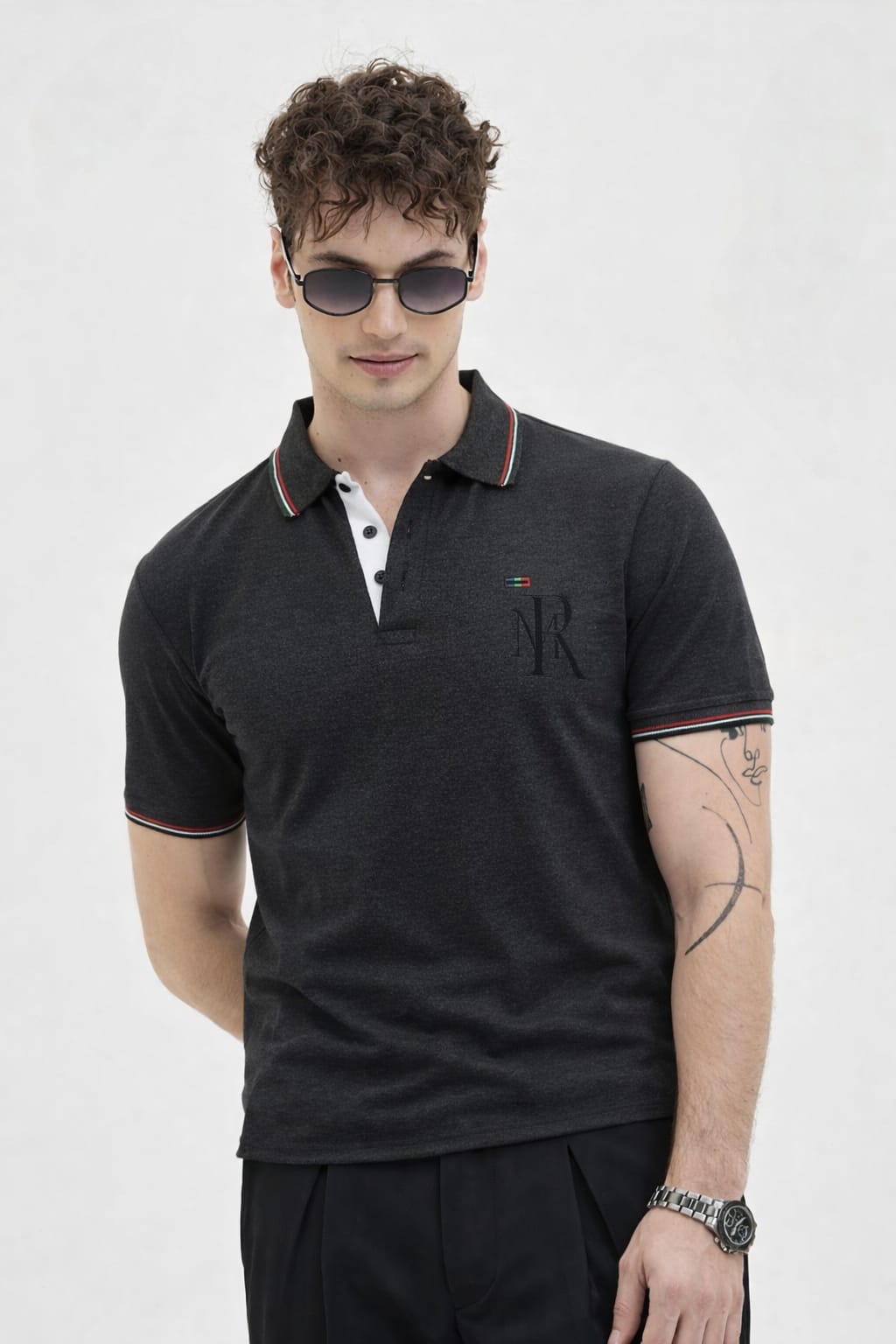 Man wearing a black polo shirt with a logo on a white background