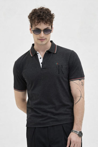 Man wearing a black polo shirt with a logo on a white background