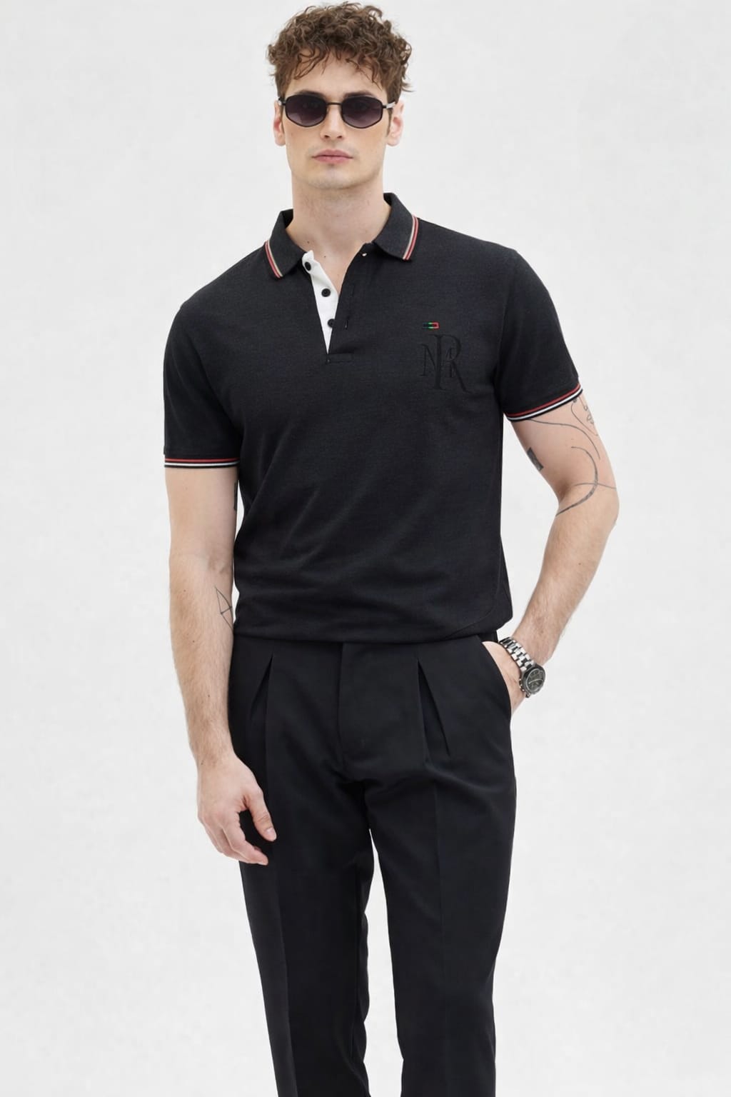 Man wearing a black polo shirt and black pants on a white background