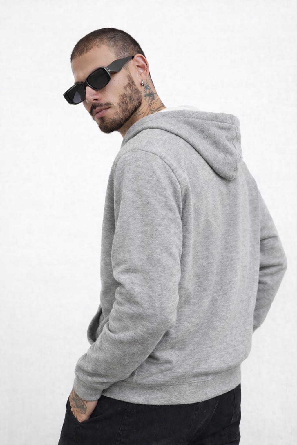 Man wearing a gray hoodie and sunglasses on a white background