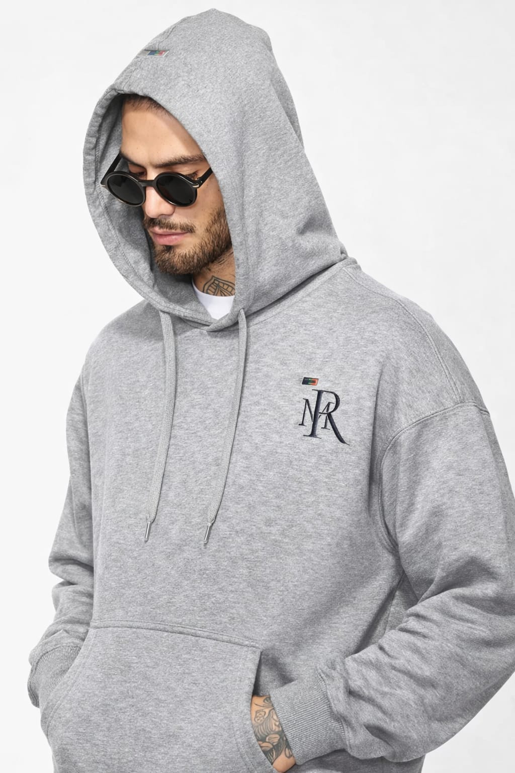 Man wearing a gray hoodie with a logo on a white background