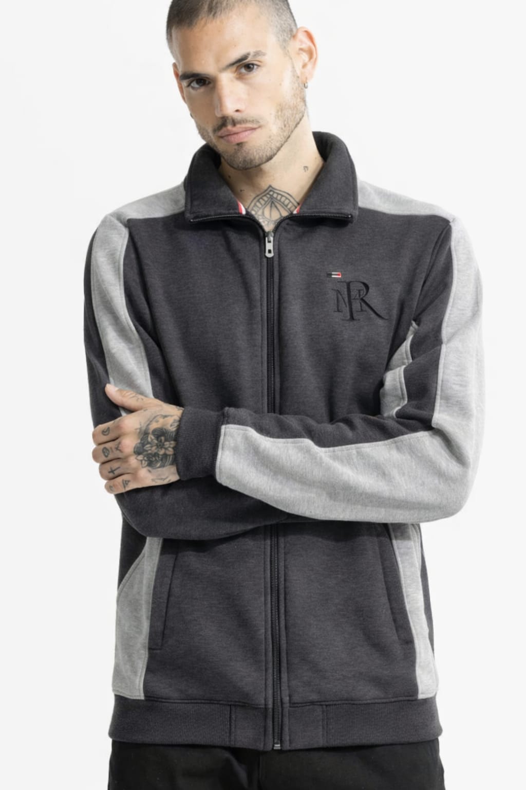 Man wearing a gray and black jacket with a logo on a white background