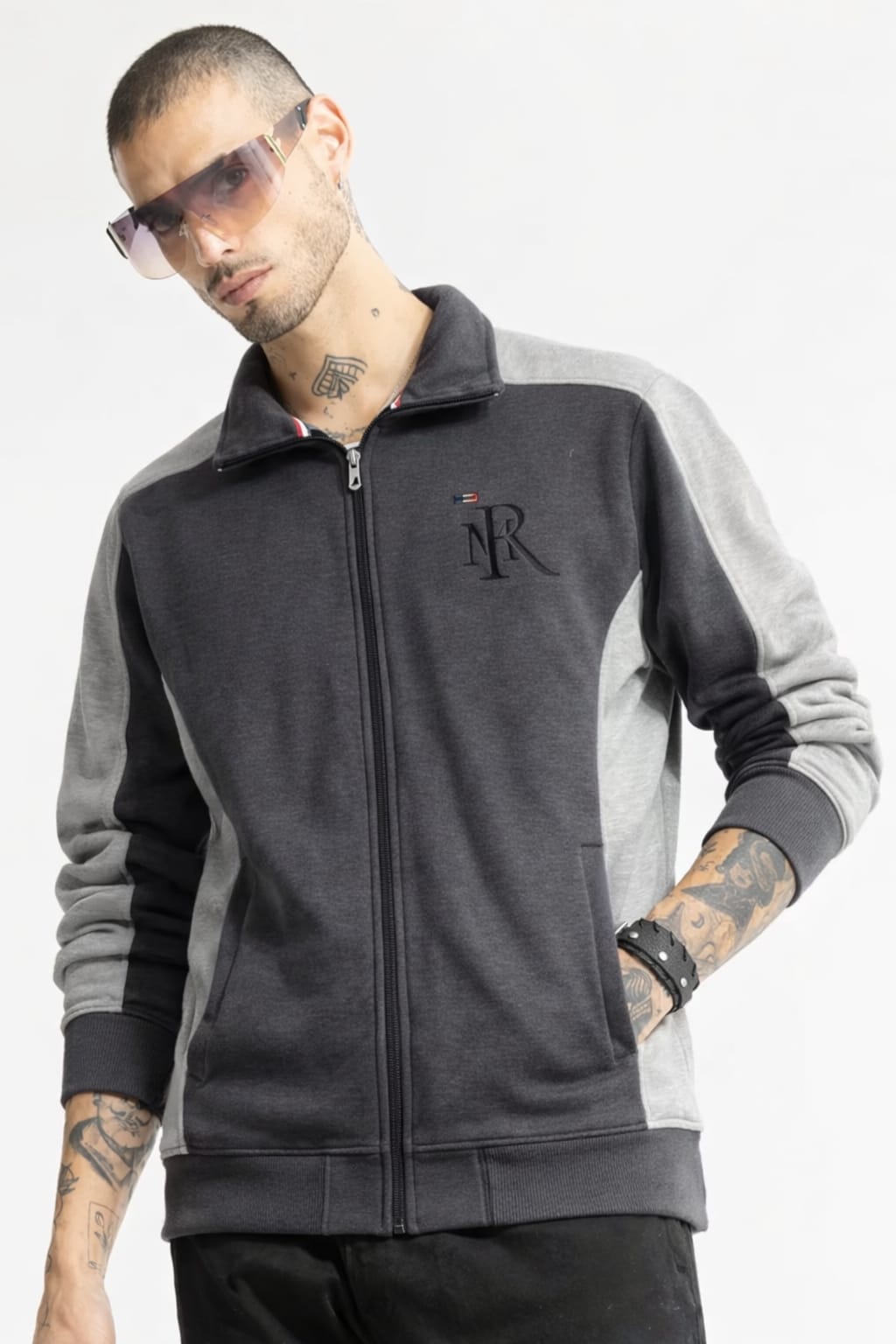 Man wearing a gray and black jacket with a logo on a white background