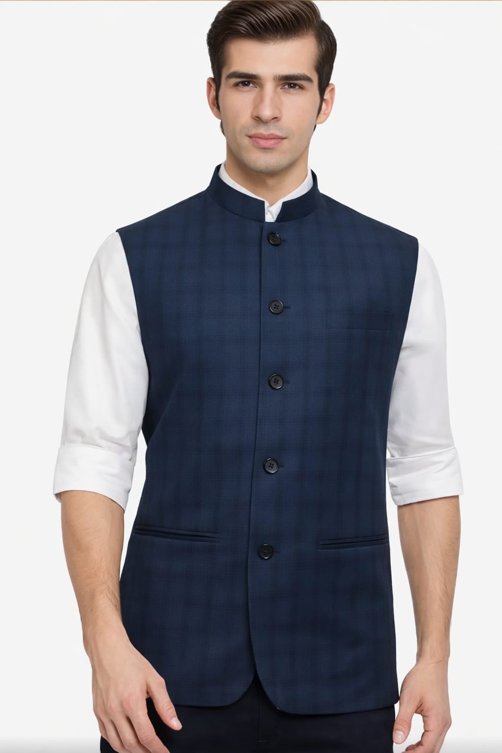 Man wearing a navy blue vest over a white shirt on a white background