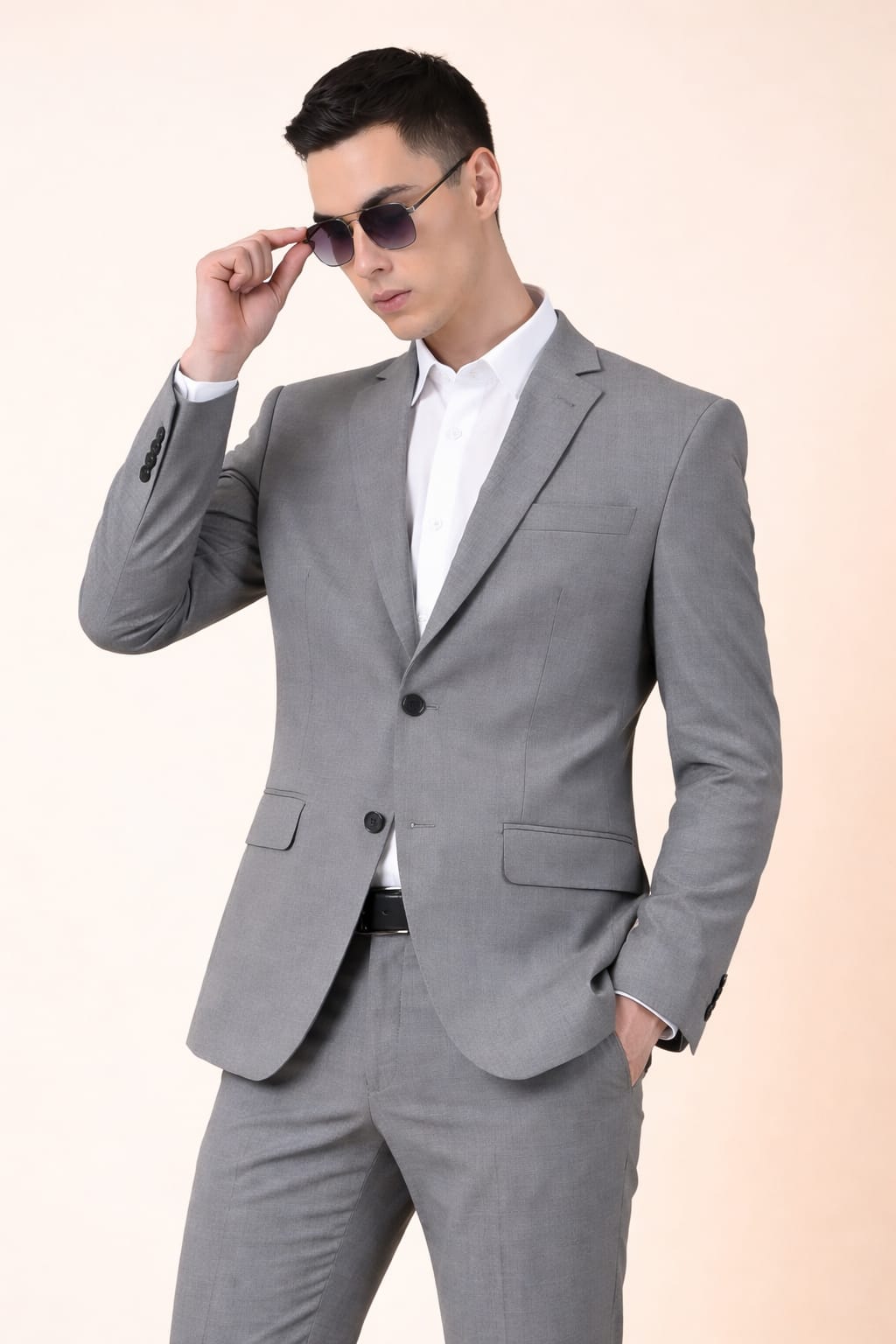 Man wearing a gray suit and sunglasses on a light pink background