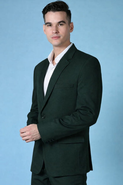 Man wearing a dark green suit against a light blue background