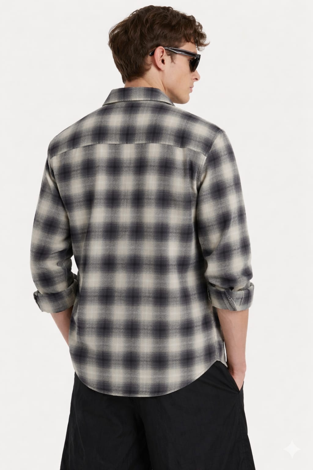 Man wearing a plaid shirt and sunglasses from behind on a white background