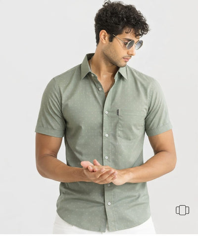 Man wearing a green short-sleeve shirt on a light gray background