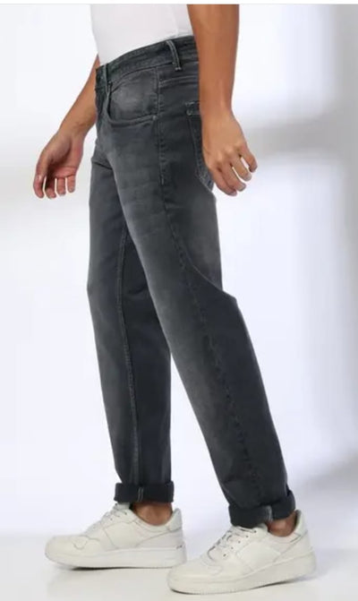 Person wearing black jeans and white sneakers on a white background