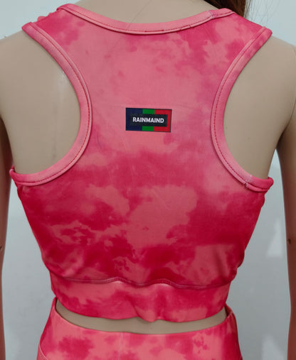 Pink tie-dye crop top with a brand logo on a plain background