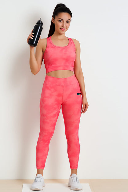 Woman in pink athletic outfit holding a water bottle on a white background