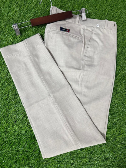 Light gray pants on a hanger against a green grass background