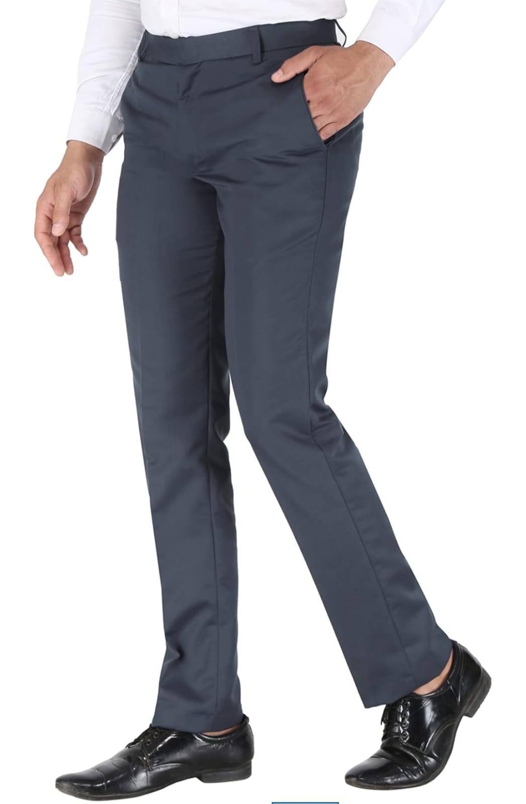 Person wearing dark gray dress pants with a white shirt and black shoes on a white background
