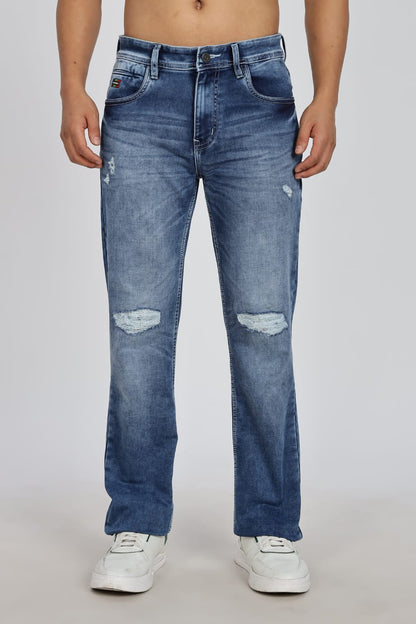 Blue distressed jeans worn by a person on a plain background