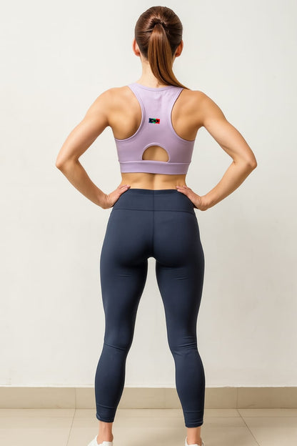 Person wearing a purple sports bra and navy leggings against a white background