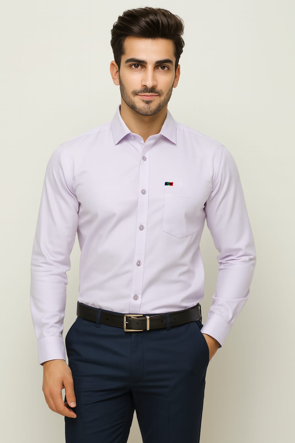 Man wearing a light purple dress shirt and navy pants against a plain background