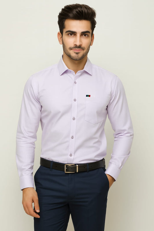 Man wearing a light purple dress shirt and navy pants against a plain background