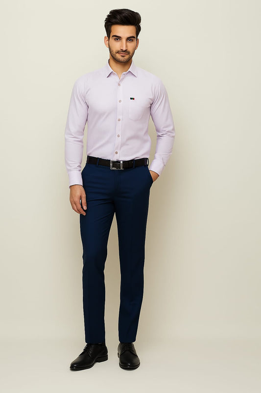 Man wearing a light purple shirt and navy pants against a beige background